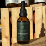 Bottle of scalp serum on a wooden surface with other bottles in the background