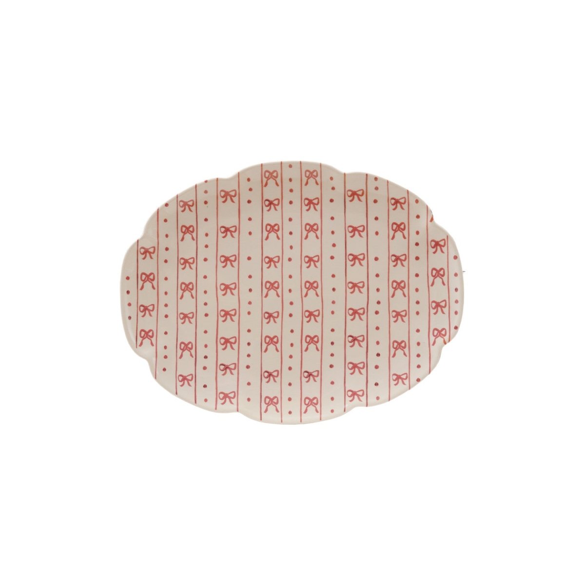 A scalloped stoneware platter with a bow pattern in white and red