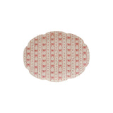 A scalloped stoneware platter with a bow pattern in white and red