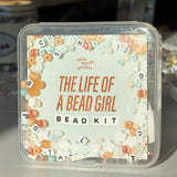 Bead kit packaging with decorative text and bead designs on a light background