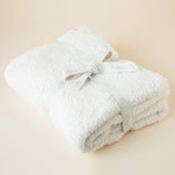 Lightweight plush throw blanket draped over a couch