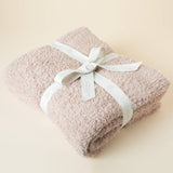 Lightweight plush throw blanket draped over a couch