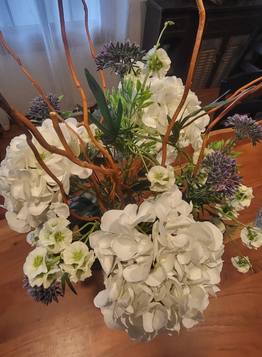 Bouquet of white hydrangeas and other flowers on a wooden surface
