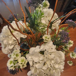 Bouquet of white hydrangeas and other flowers on a wooden surface
