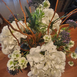Bouquet of white hydrangeas and other flowers on a wooden surface